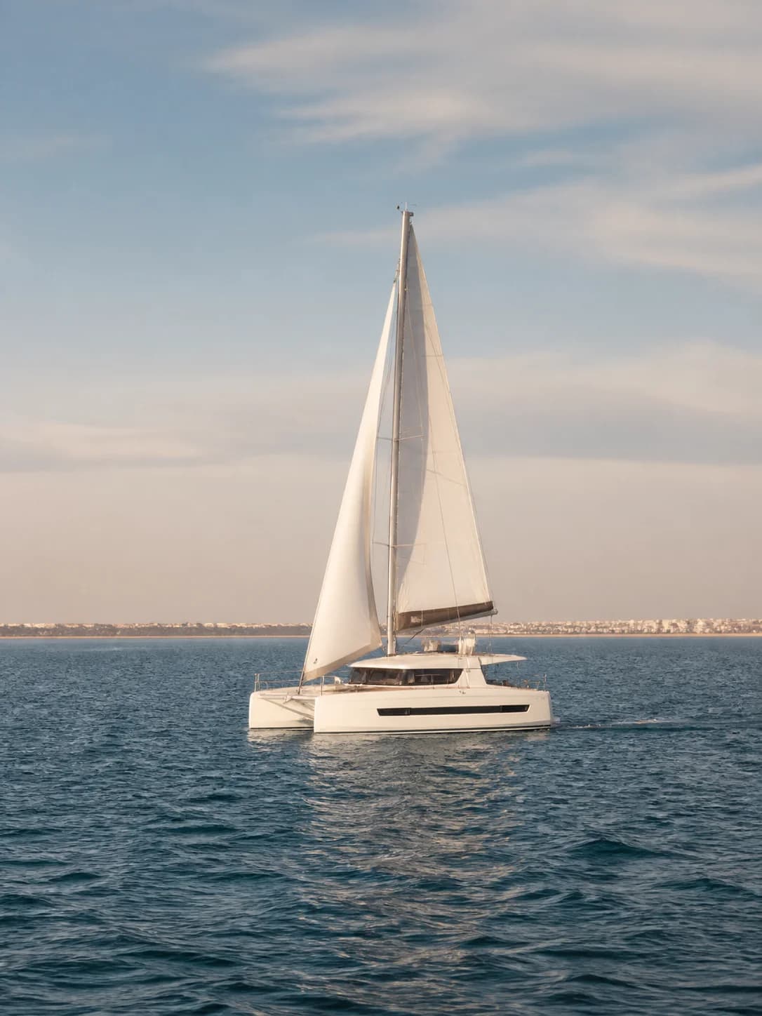 Catamarán blanco navegando a vela por la Bahía de Cádiz