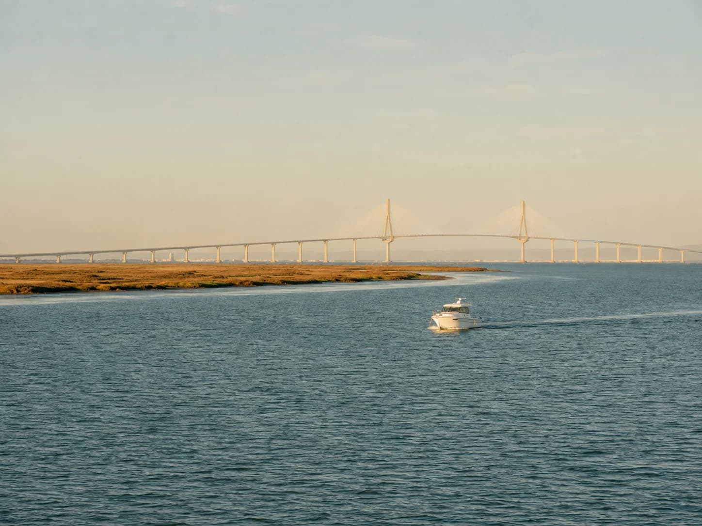 Barco recorriendo la Bahía de Cádiz cerca de Puerto Real con el puente al fondo
